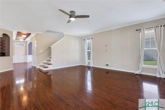 unfurnished living room featuring ceiling fan, ornamental molding, and dark wood-type flooring