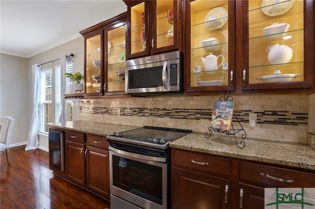 kitchen featuring light stone countertops, appliances with stainless steel finishes, dark hardwood / wood-style flooring, and crown molding