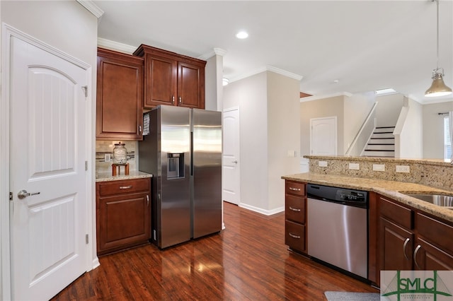 kitchen featuring pendant lighting, dark wood-type flooring, crown molding, decorative backsplash, and stainless steel appliances