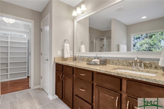 bathroom with a shower with door, vanity, and wood-type flooring