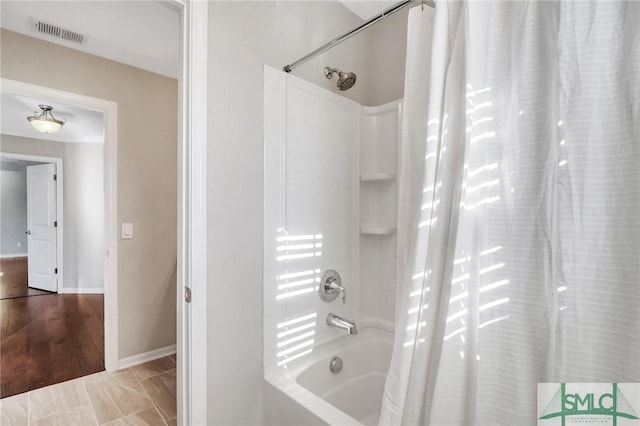 bathroom featuring hardwood / wood-style flooring and shower / tub combo with curtain