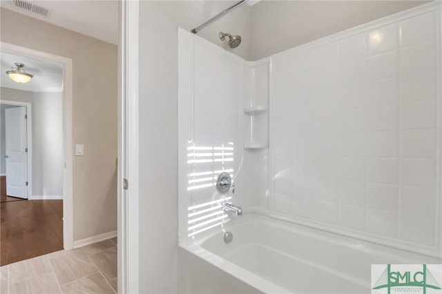 bathroom with hardwood / wood-style floors and shower / tub combination