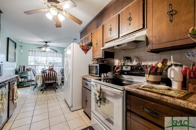 kitchen with decorative backsplash, light tile patterned floors, stainless steel appliances, and ceiling fan