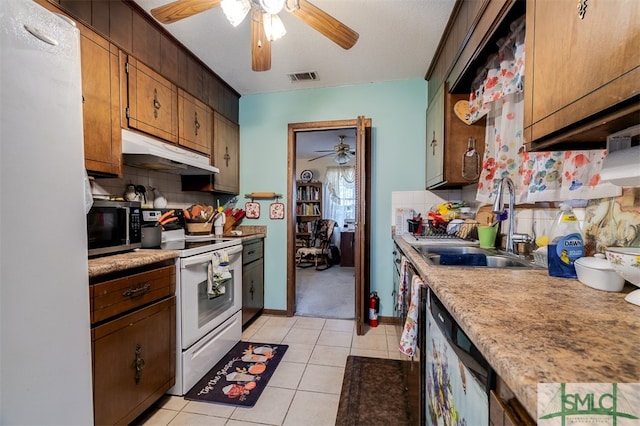 kitchen with sink, tasteful backsplash, a textured ceiling, light tile patterned floors, and appliances with stainless steel finishes