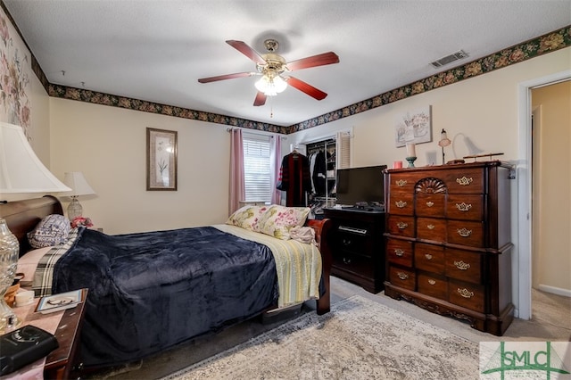 carpeted bedroom featuring a textured ceiling, a closet, and ceiling fan