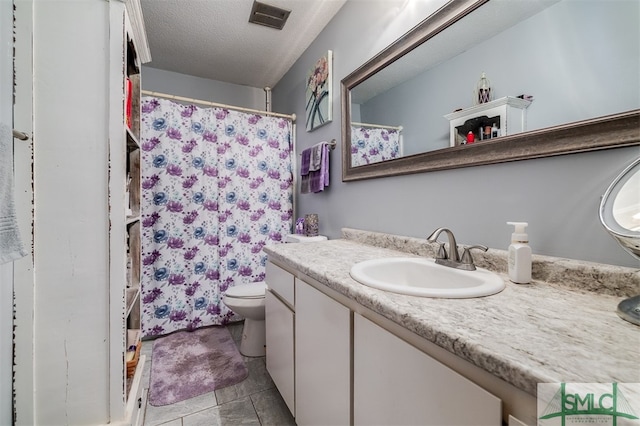 bathroom featuring tile patterned floors, vanity, toilet, and a textured ceiling