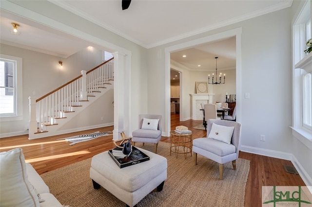 living room featuring hardwood / wood-style floors, a chandelier, and ornamental molding