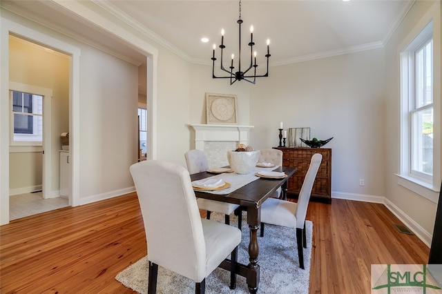 dining area featuring ornamental molding, a chandelier, and light wood-type flooring