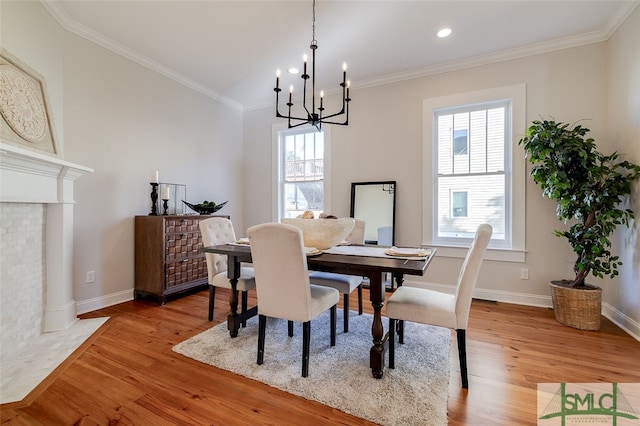 dining area featuring light hardwood / wood-style floors, an inviting chandelier, and ornamental molding