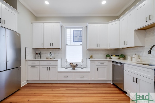 kitchen featuring white cabinets, crown molding, sink, and stainless steel appliances