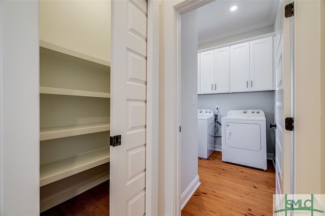 laundry room featuring separate washer and dryer, ornamental molding, and light hardwood / wood-style flooring