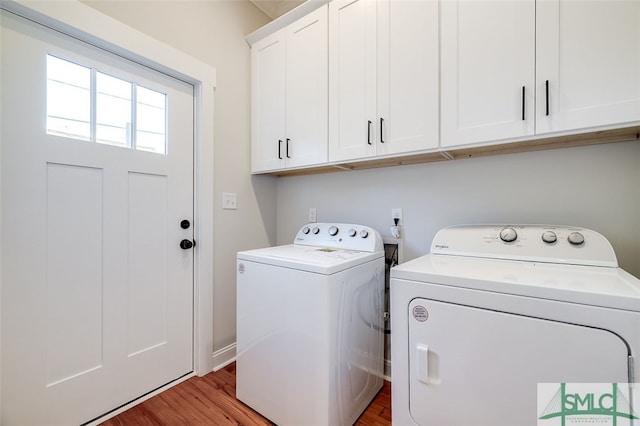 laundry area featuring cabinets, independent washer and dryer, and wood-type flooring