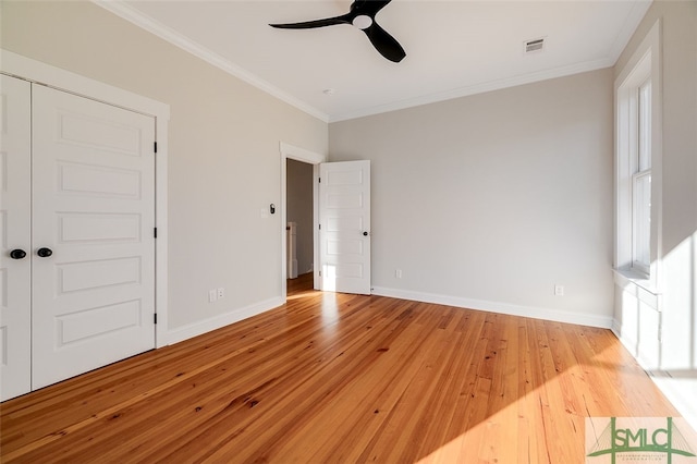 unfurnished bedroom featuring a closet, light hardwood / wood-style flooring, ceiling fan, and ornamental molding