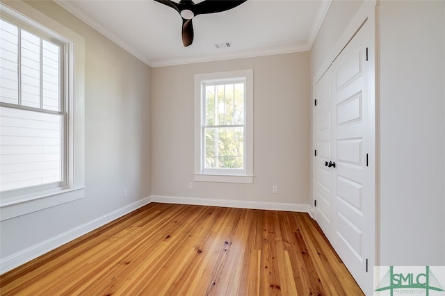 empty room featuring ceiling fan, ornamental molding, and light wood-type flooring