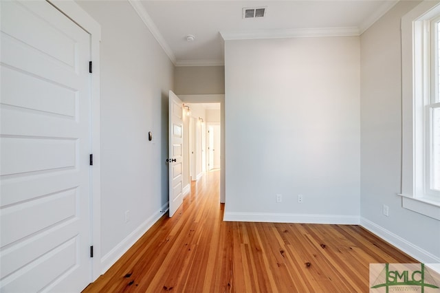 interior space featuring light wood-type flooring, ornamental molding, and a wealth of natural light