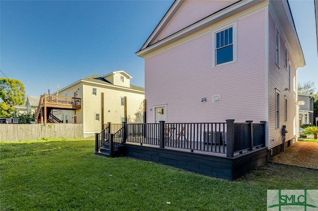 rear view of property featuring a yard and a wooden deck