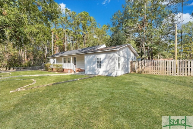 back of property featuring a lawn and covered porch