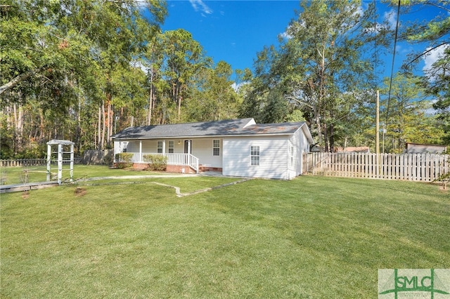 rear view of property featuring a lawn and covered porch