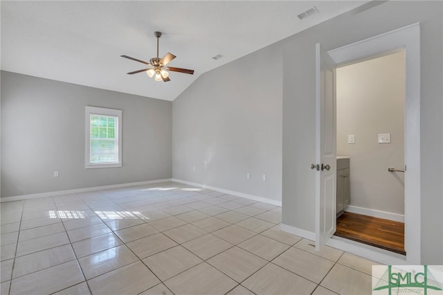 tiled empty room featuring ceiling fan and lofted ceiling