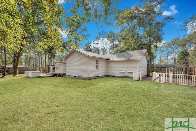 rear view of property with a hot tub, a wooden deck, and a lawn