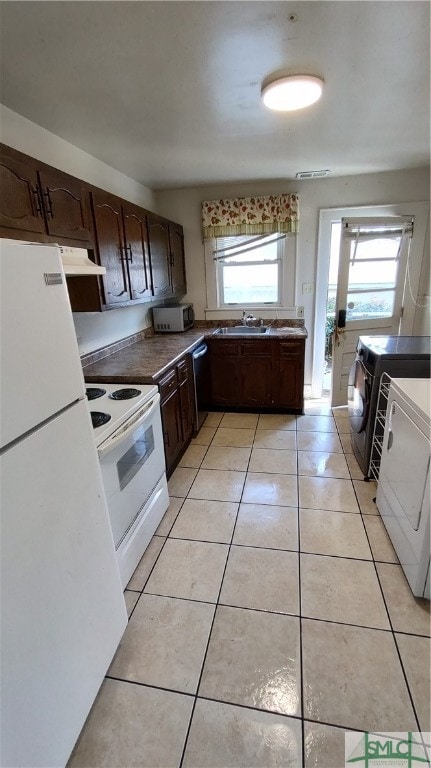 kitchen featuring dark brown cabinetry, washer and clothes dryer, plenty of natural light, and appliances with stainless steel finishes