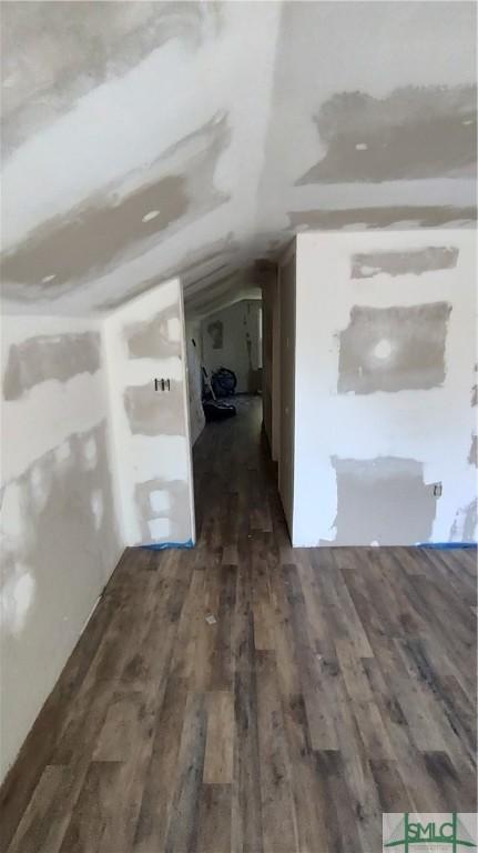 interior space with dark hardwood / wood-style flooring and lofted ceiling