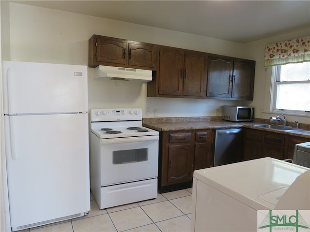 kitchen featuring dark brown cabinets, light tile patterned floors, sink, and appliances with stainless steel finishes