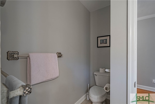 bathroom featuring hardwood / wood-style flooring, toilet, and crown molding