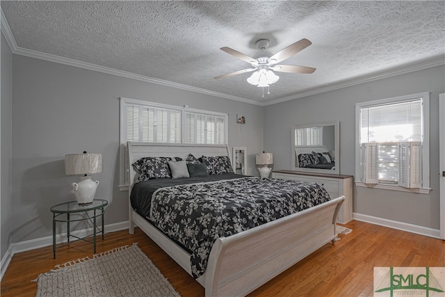 bedroom with a textured ceiling, ceiling fan, wood-type flooring, and crown molding