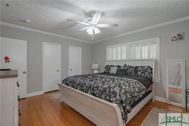 bedroom featuring a textured ceiling, hardwood / wood-style flooring, ceiling fan, and crown molding