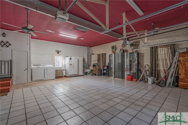 garage featuring ceiling fan, separate washer and dryer, a garage door opener, and white refrigerator with ice dispenser