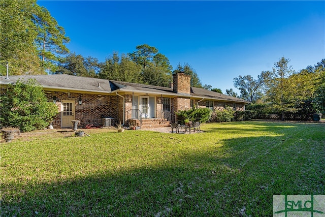 rear view of house featuring a lawn