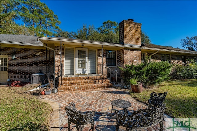 rear view of property with a lawn, a patio area, and cooling unit