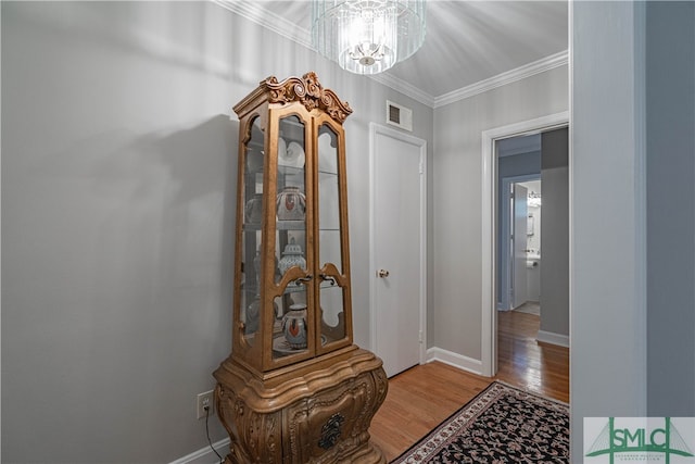 interior space featuring a chandelier, crown molding, and wood-type flooring