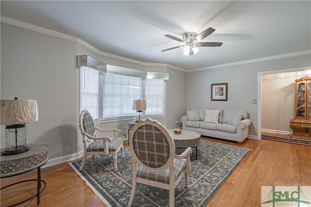 living room with wood-type flooring, ceiling fan, and crown molding