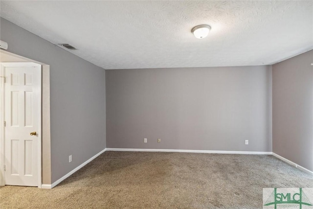 carpeted empty room with a textured ceiling