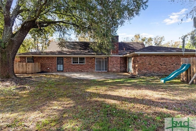 rear view of property with a lawn and a patio area