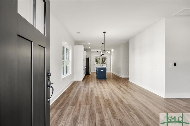 interior space with light wood-type flooring and a chandelier