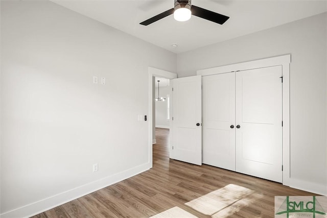 unfurnished bedroom featuring ceiling fan, a closet, and light hardwood / wood-style flooring