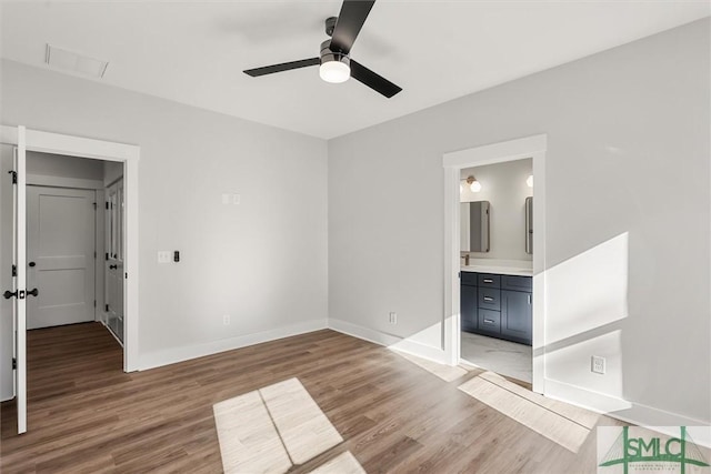 unfurnished bedroom with ceiling fan, light hardwood / wood-style floors, and ensuite bath