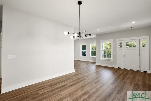 foyer entrance with wood-type flooring and a chandelier