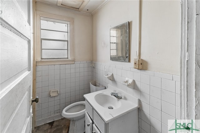 bathroom with vanity, toilet, and tile walls