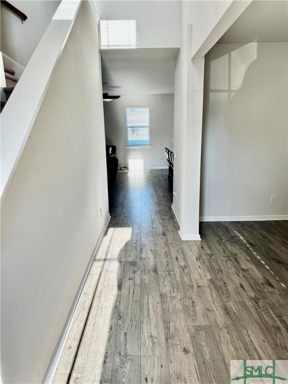 hallway featuring stairway, baseboards, and wood finished floors