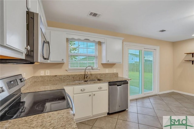 kitchen with a wealth of natural light, white cabinetry, dishwasher, sink, and black electric range