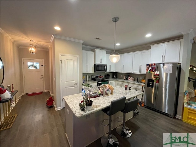 kitchen with pendant lighting, dark wood-type flooring, ornamental molding, white cabinetry, and stainless steel appliances