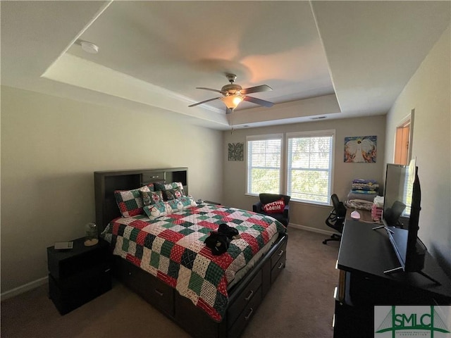 bedroom featuring carpet, a tray ceiling, and ceiling fan