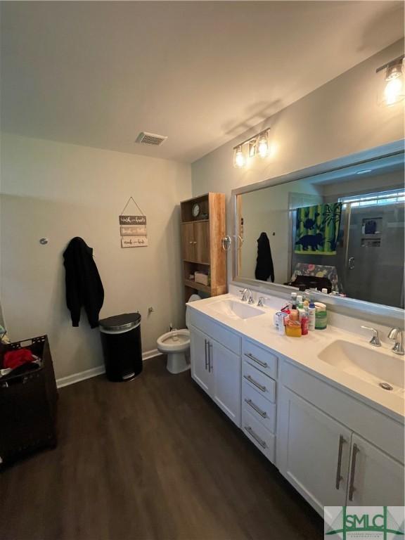 bathroom with hardwood / wood-style flooring, vanity, and an enclosed shower