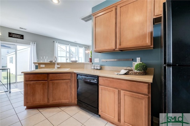 kitchen featuring light tile patterned flooring, sink, kitchen peninsula, and black appliances