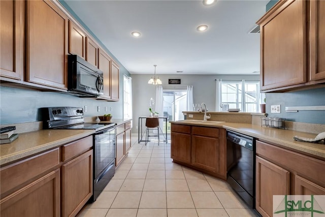 kitchen with sink, black appliances, light tile patterned floors, pendant lighting, and a notable chandelier