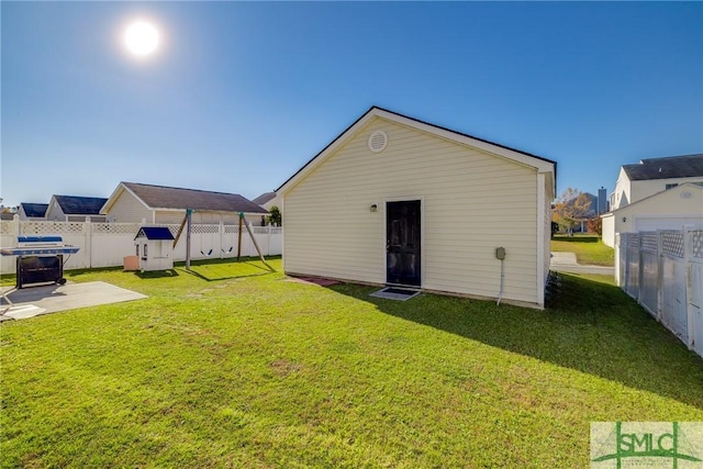 back of property featuring a yard and an outbuilding